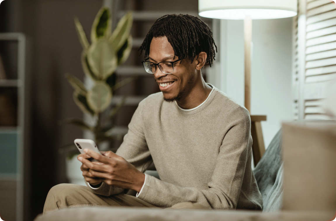 homem negro com moletom mexendo no celular